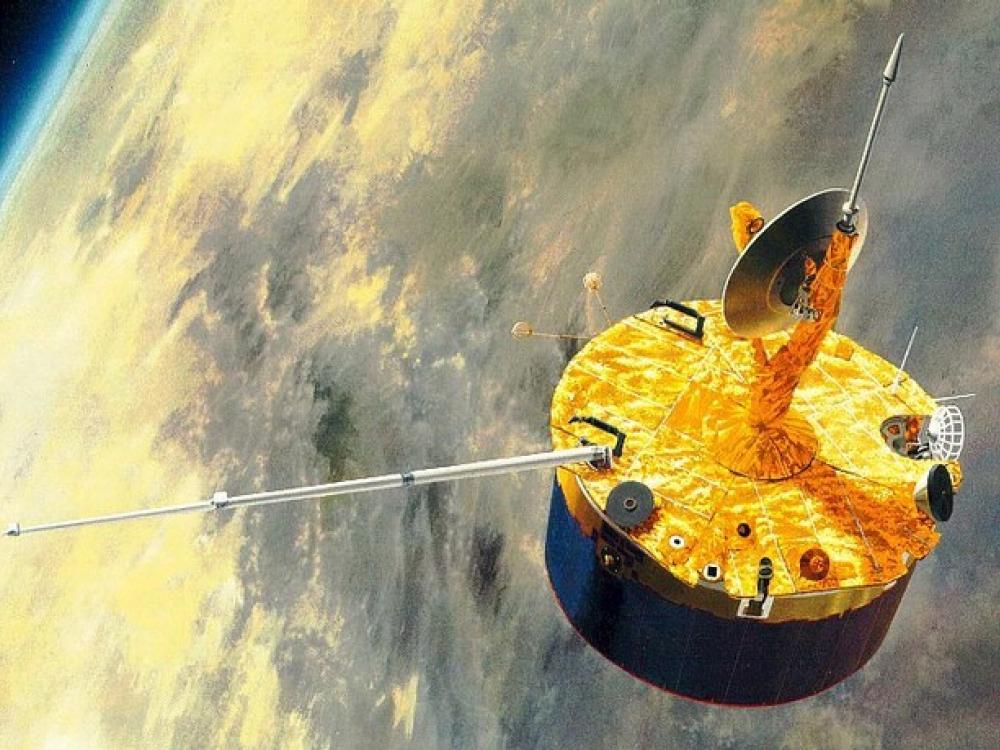 An artist's depiction of a cylinder-shaped orbiter with a satellite and multiple antennae orbiting over Venus.