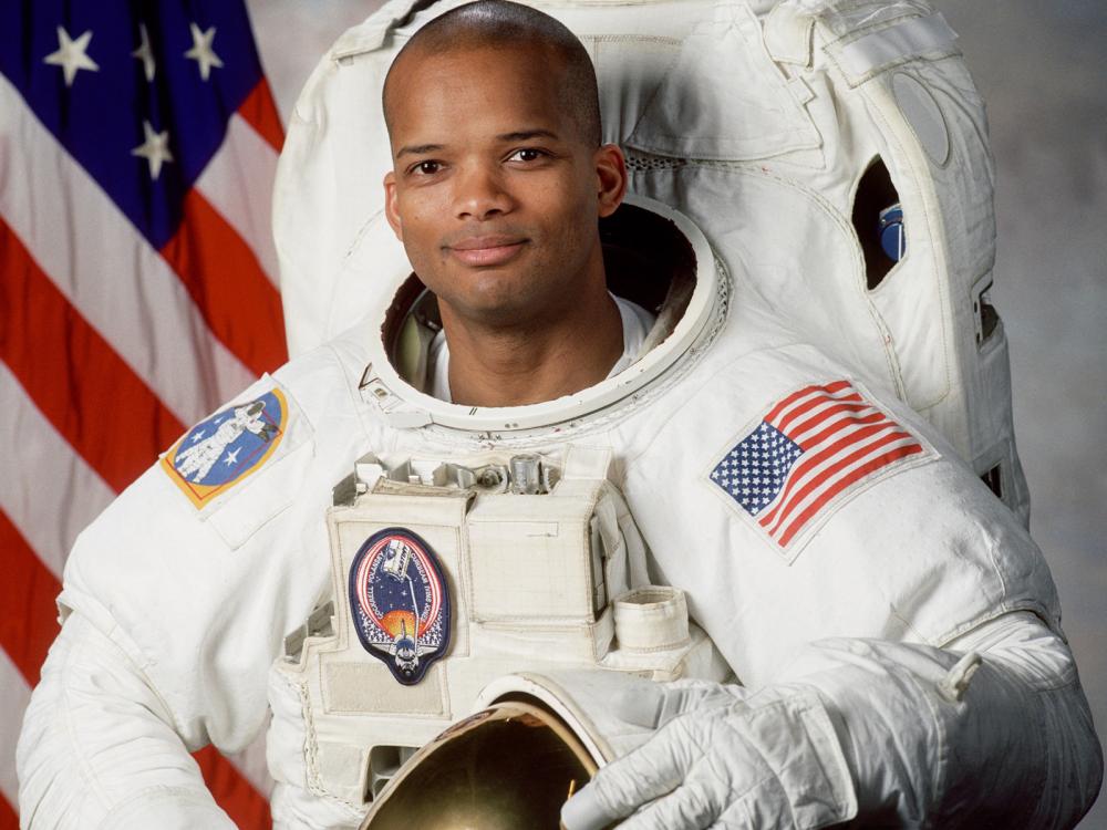 Robert L. Curbeam Jr., an African-American male astronaut, poses formally inside his astronaut suit.