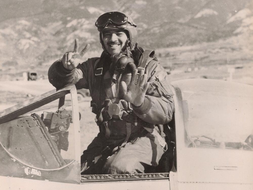 man in aircraft smiling and holding up seven fingers