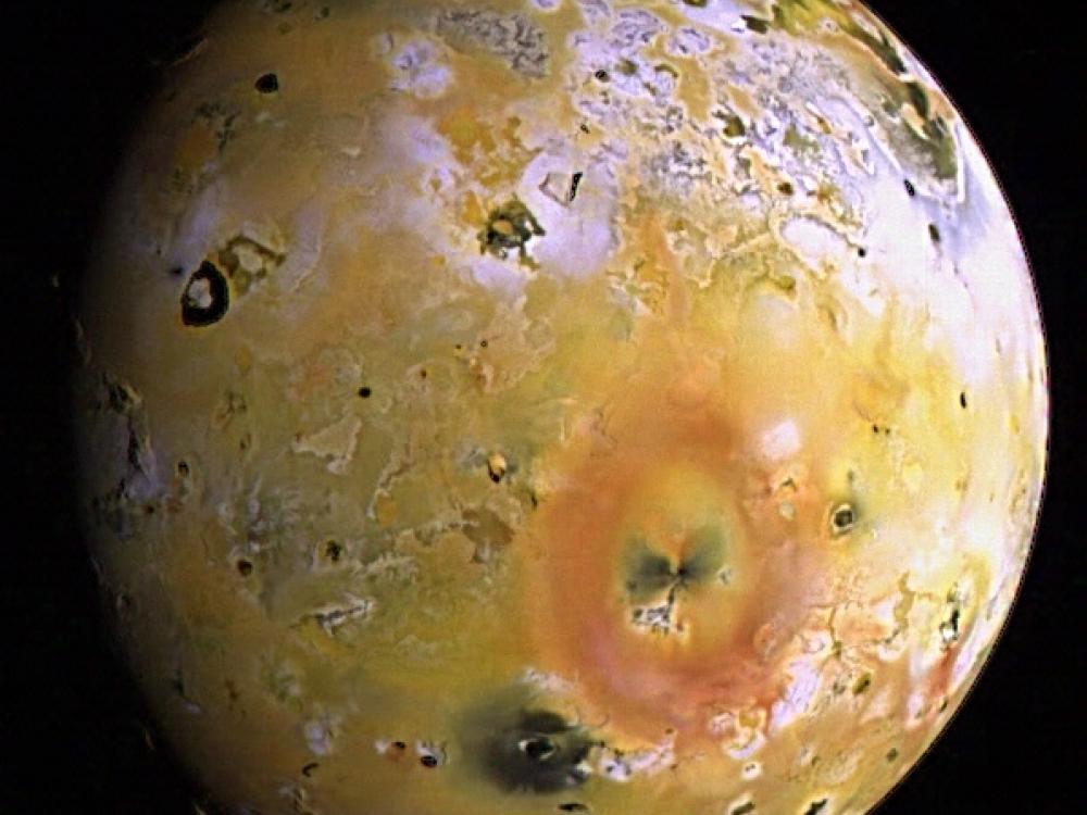 A partial view of Io, Jupiter's closest large moon, and its topography and view of some volcanoes.