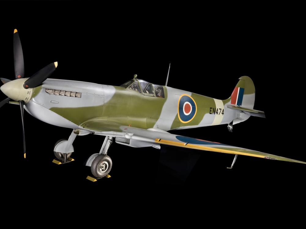 Overall, three-qaurter side view of green and blue Spitfire aircraft