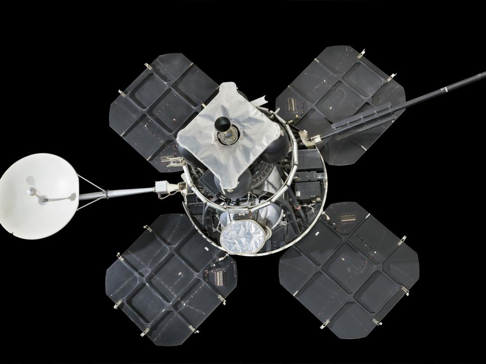 Lunar lander with four square solar panels attached to central instrument box and round satellite dish