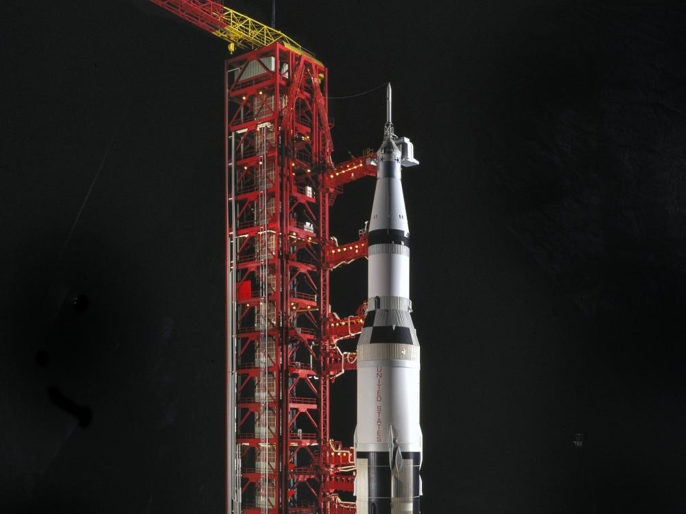 Scale model of black and white Saturn V Rocket with launch pad