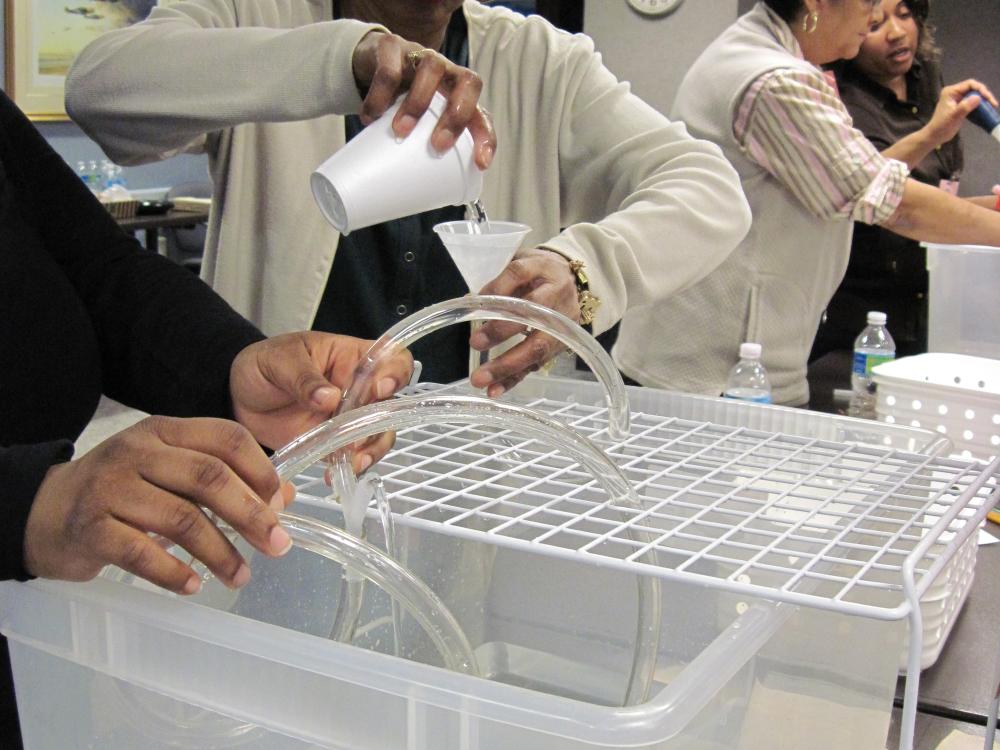 Teachers pour liquid between containers.