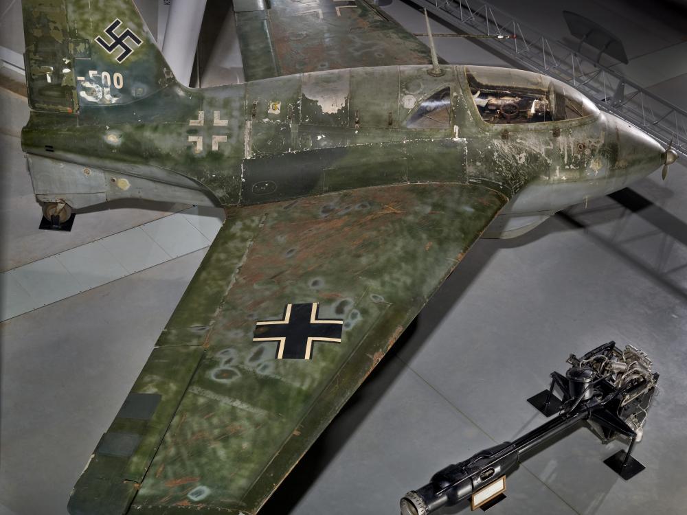 Side view of a green camouflaged German World War II aircraft on display in the Museum.