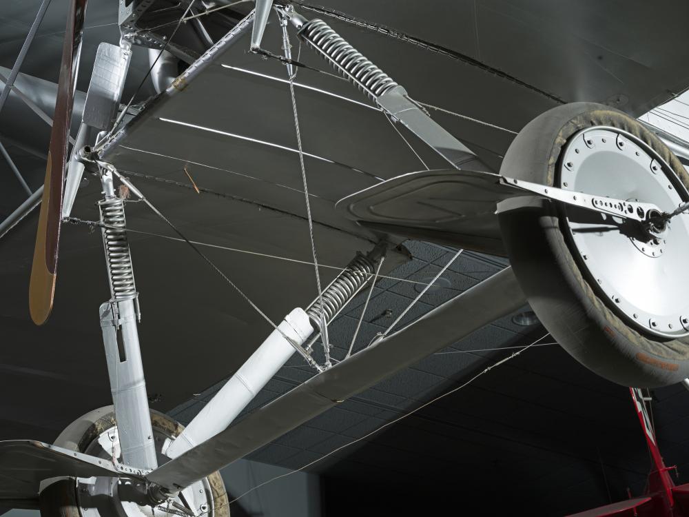 Closeup view of two wheels and metal wheel frame from a Voisin Type 8 aircraft, seen from below