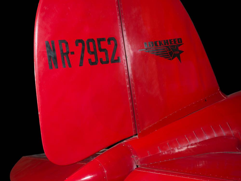 Tail of red Amelia Earhart Lockheed Vega 5B aircraft with "NR-7952" and lockheed logo in black