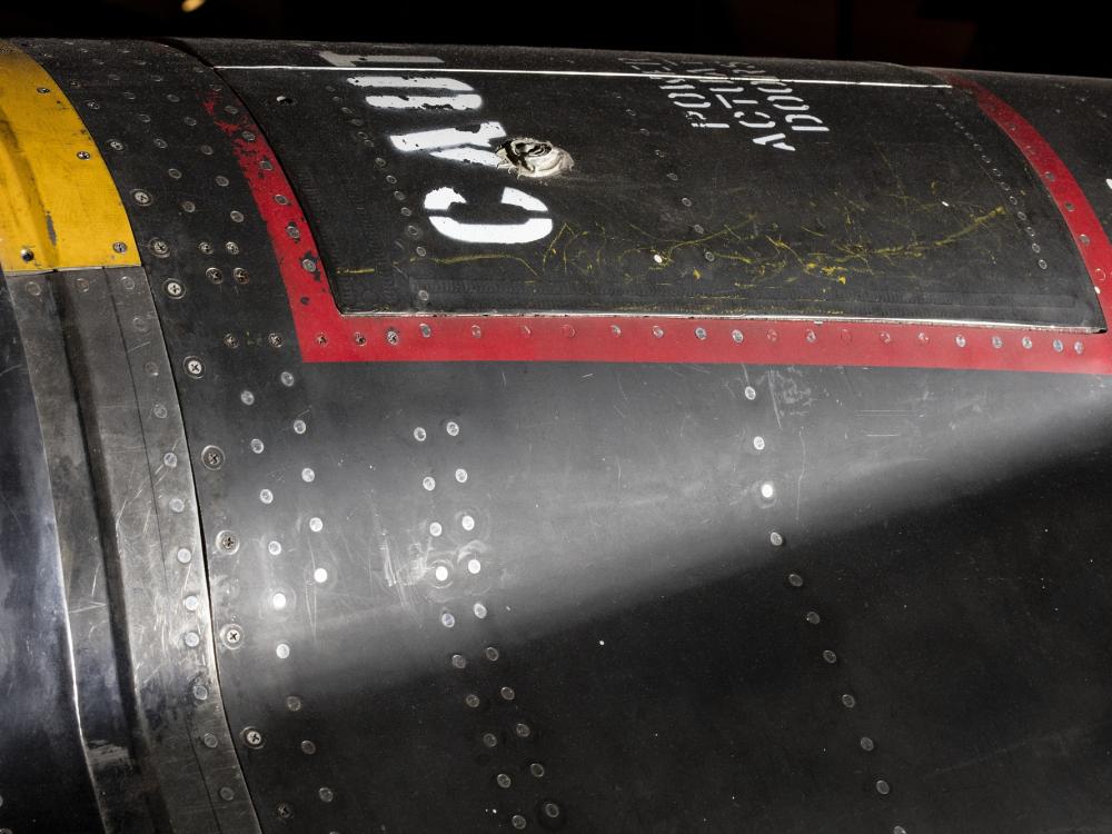 Red square outline and "Caution" in white lettering on black titanium North American x-15 aircraft