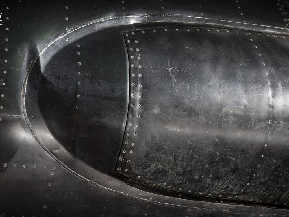 Long rounded bump on side of black titanium North American x-15 aircraft