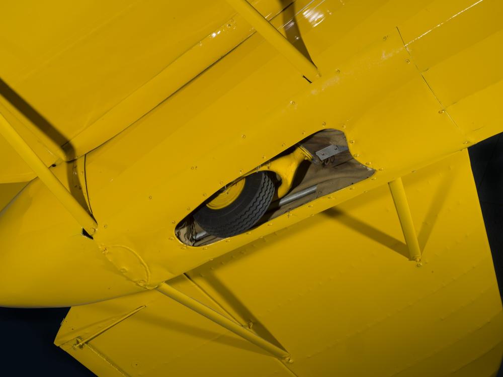 View of undercarriage and retractable landing gear tire on back of Staggerwing aircraft