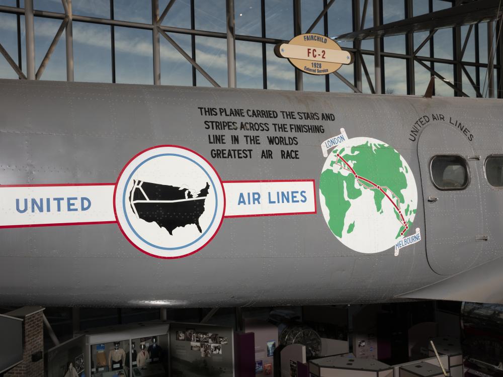 United States Airlines logo, globe, and record details on side of gray Boeing 247-D aircraft in museum