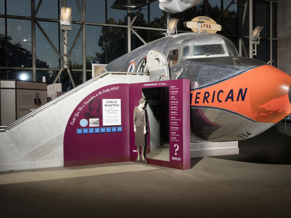 Cutoff of Douglas DC-7 aircraft in museum with exhibit panels next to stairs into aircraft