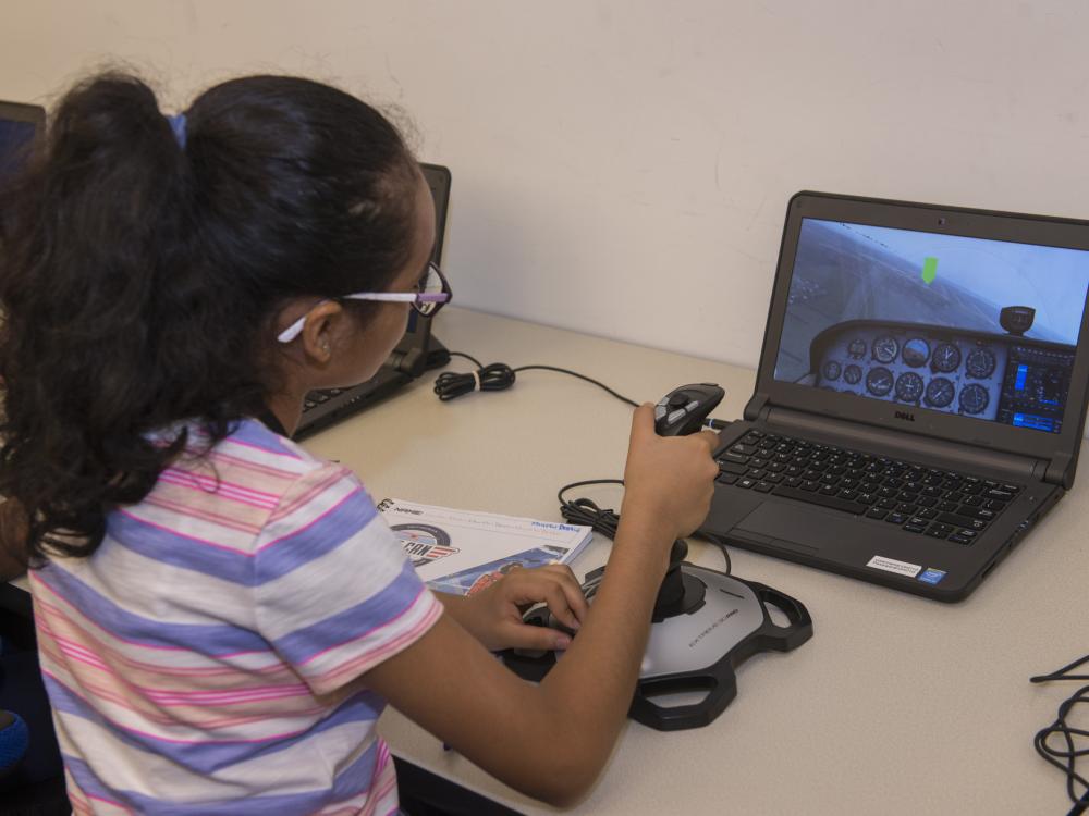 A student attending the "She Can" STEM camp flies a Cessna simulator at the Steven F. Udvar-Hazy Center.