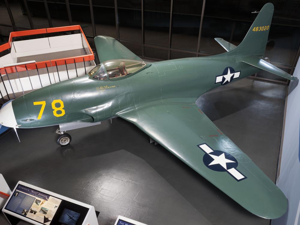 Side view of dark green military monoplane with one engine. Monoplane is on display in the museum.