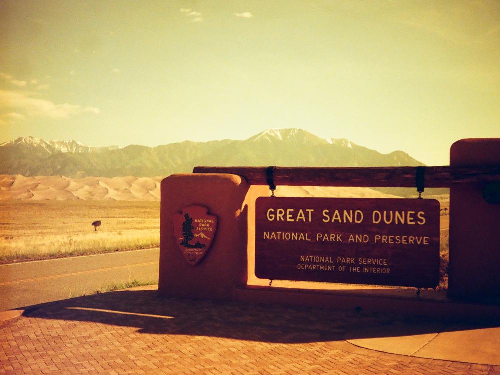 Filtered image of the welcome sign for the Great Sand Dunes. 