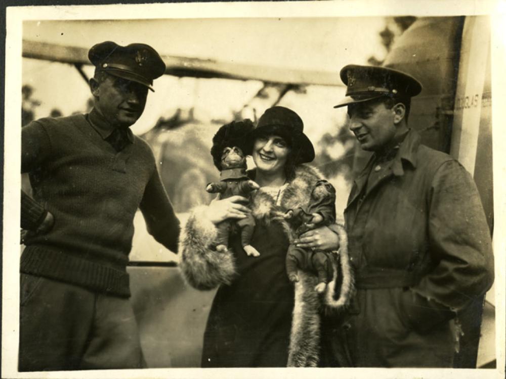 A woman holding two monkeys