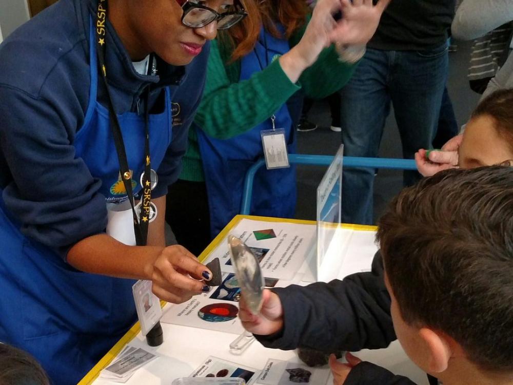 Volunteer Miché Aaron working with young visitors at one of the Museum’s Discovery Stations