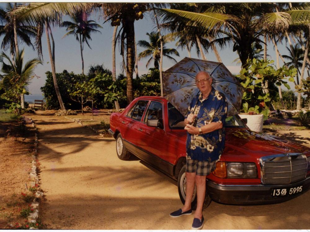 Arthur Clarke near the beach in Sri Lanka, leaning on his car, early 2000s. 