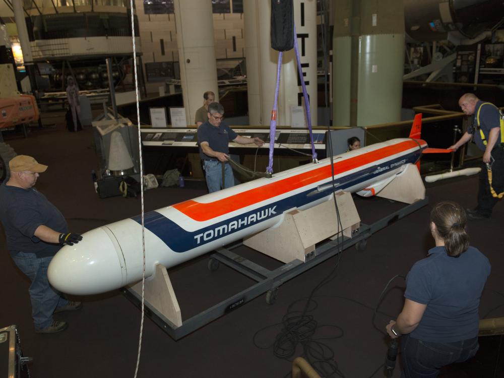 Staff encircle the missile as it is lowered to the ground