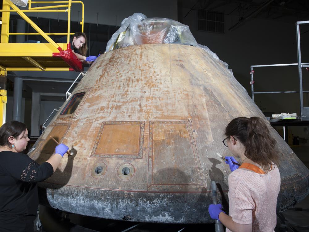 Conservators work on the Command Module Columbia