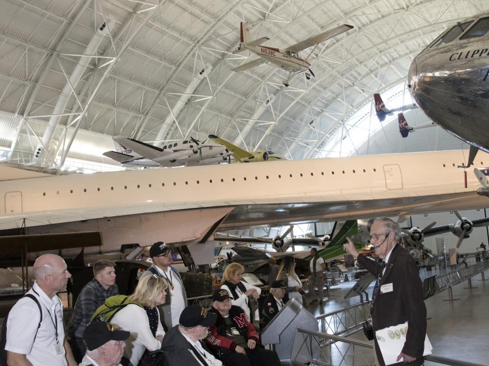 A group of veterans touring the Steven F. Udvar-Hazy Center in Chantilly, VA with a docent.