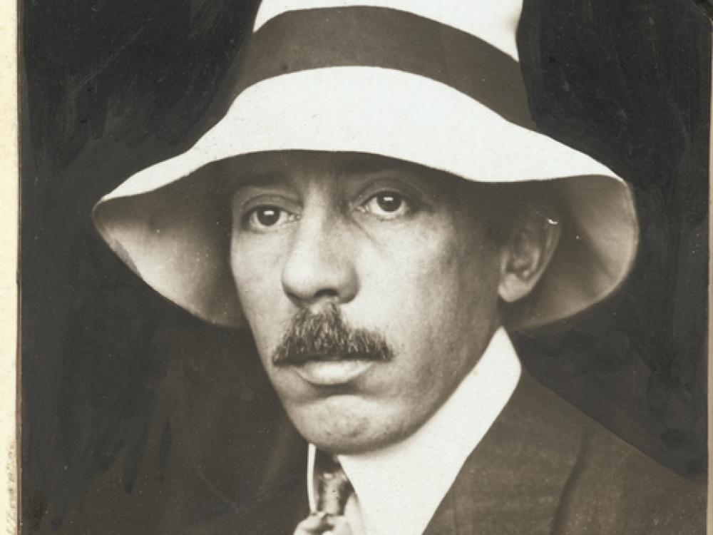 Head-and-shoulders portrait photo of Alberto Santos-Dumont, wearing light colored hat.