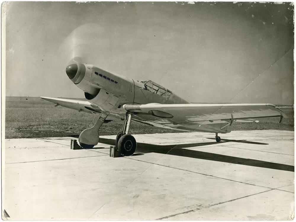 Messerschmitt on concrete with cholks on front wheels, nose facing the camera. 