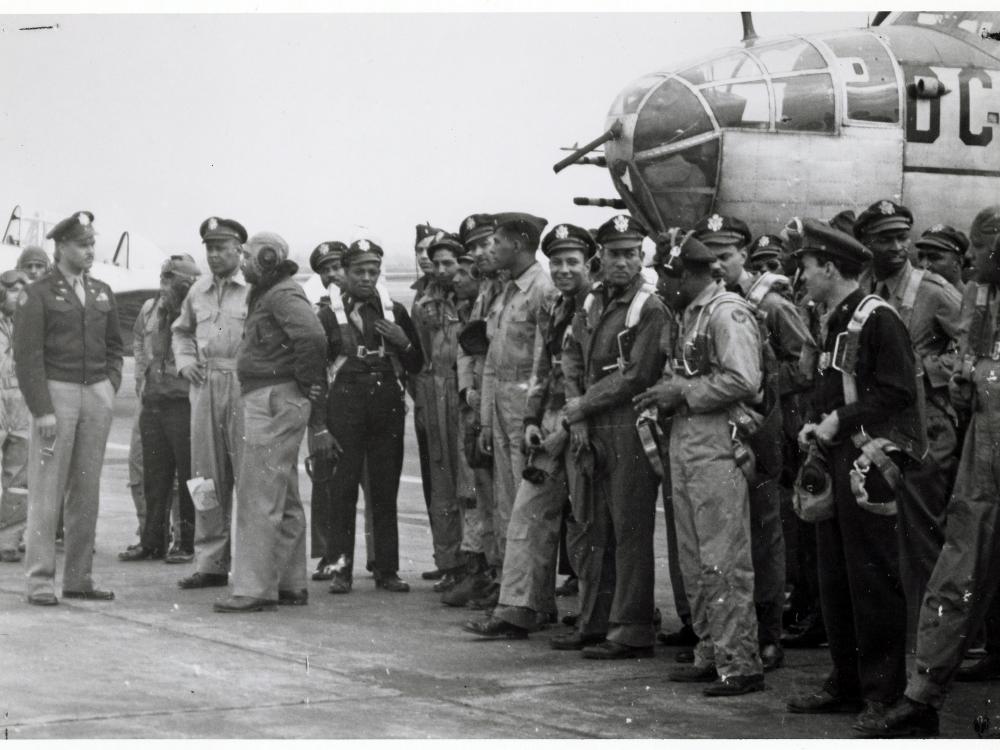 Group of African American airmen in front of aircraft