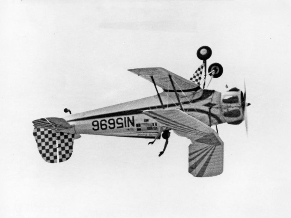 Black and white photo of the aircraft with pilot's hands in the air. 