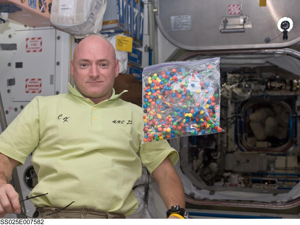 A photo of NASA engineer Scott Kelly with a bag of candy aboard the International Space Station.