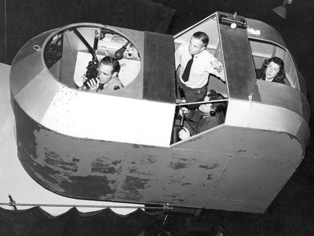 A woman with three male students in a simulator. 