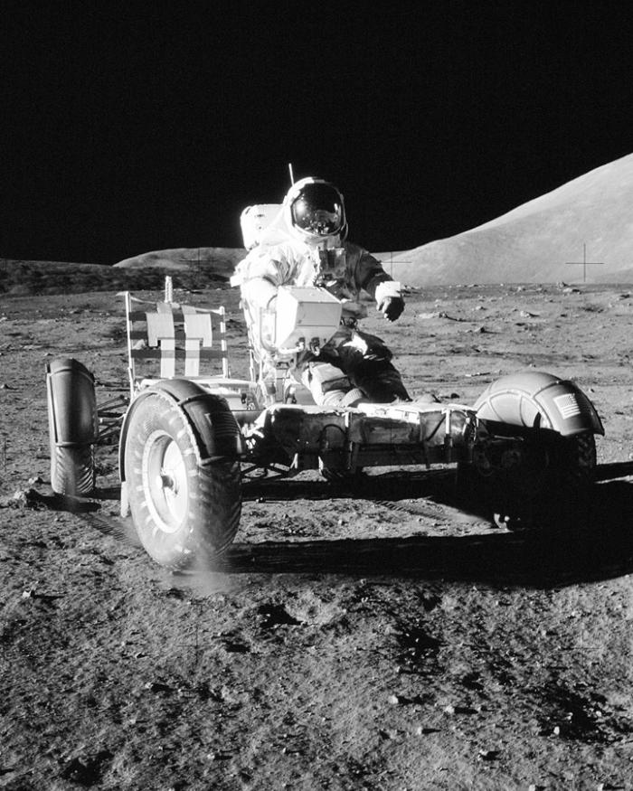 An astronaut in a space suit on a cart on the moon.