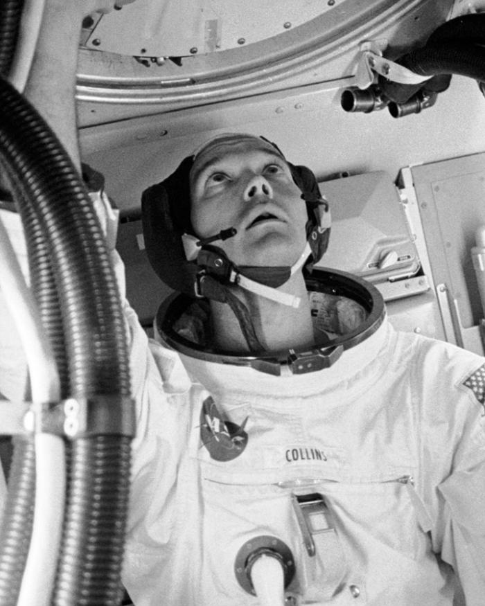 A man in a spacesuit looks up. 