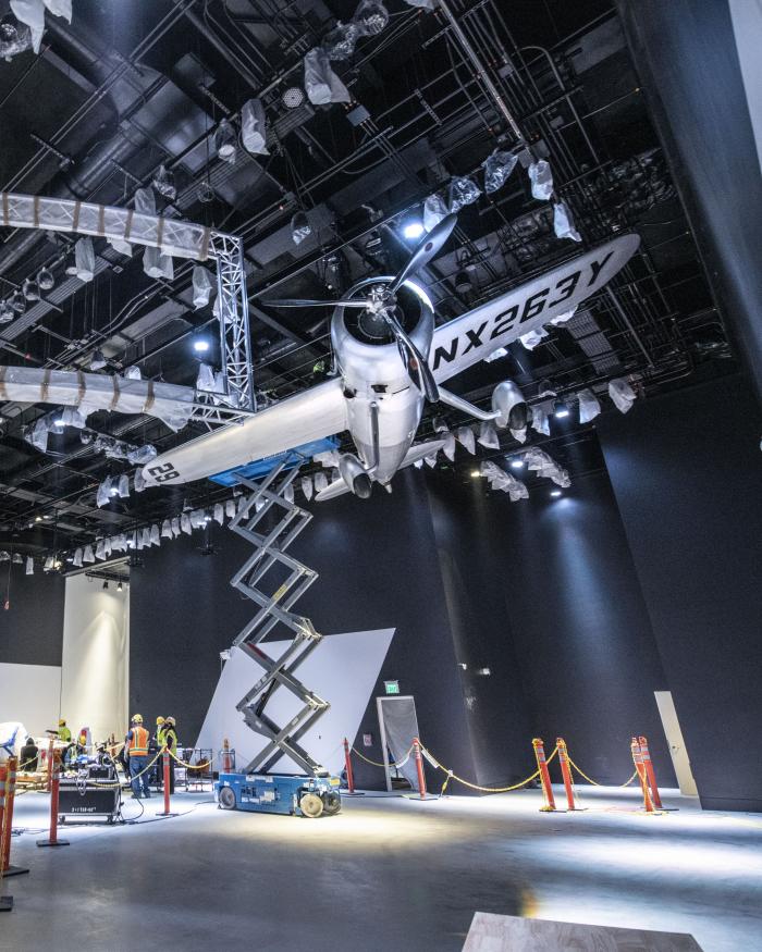 An airplane hangs above an open gallery.