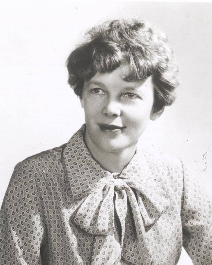 A woman models a dress with a tie at the neck. 
