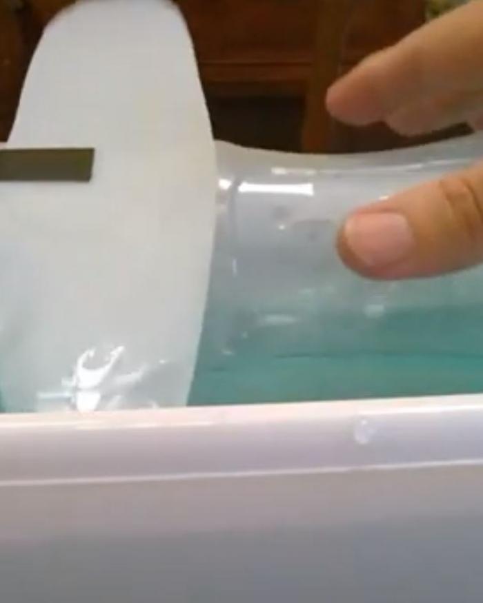 A model plane made out of a water bottle floats in water. 