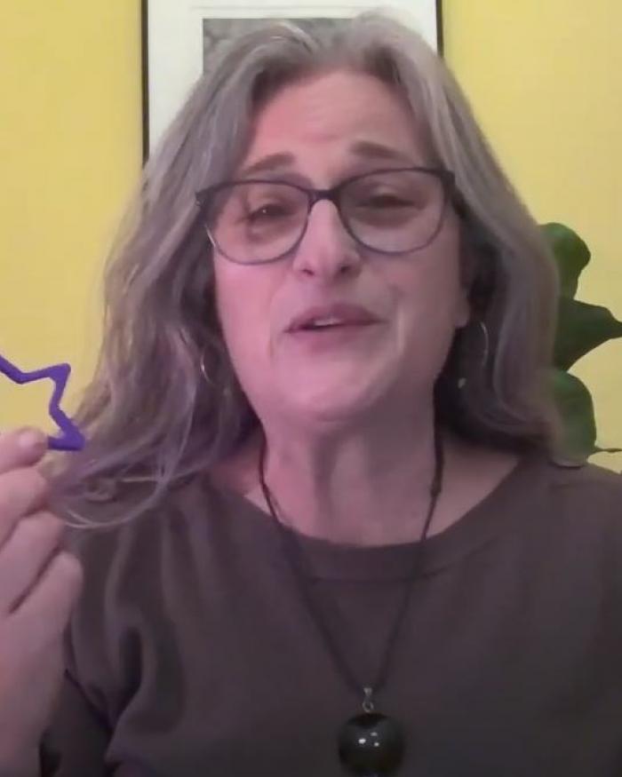 A woman holds a star shaped cookie cutter. 