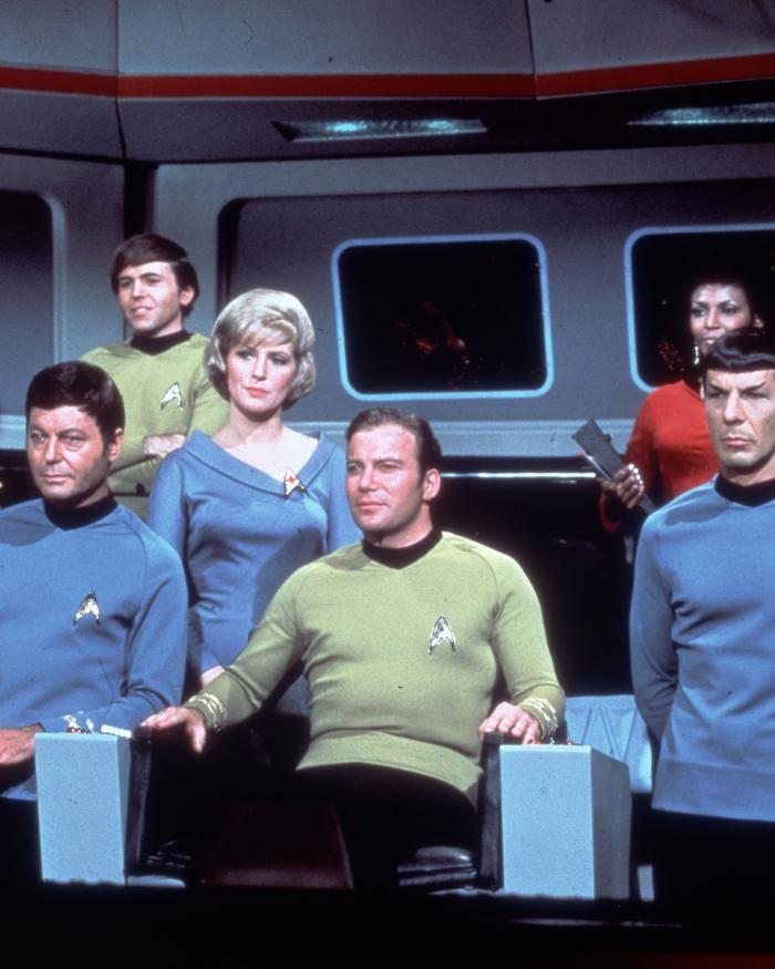 Star Trek cast stands on bridge of Starship Enterprise.