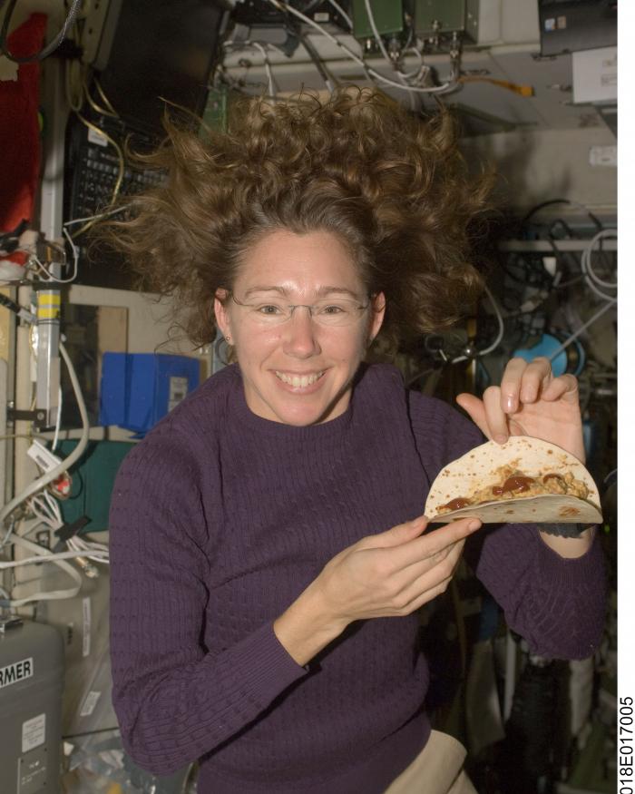 Astronaut Sandra Magnus poses for a photo with a tortilla sandwich which she prepared aboard the ISS.