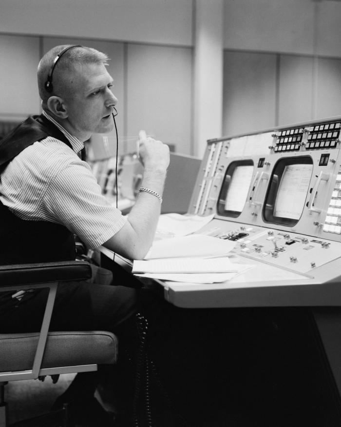 Black and white photo, man sitting at console
