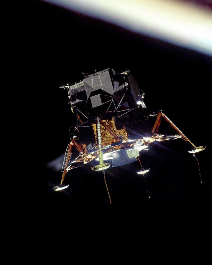 Lunar module floating in space above the horizon