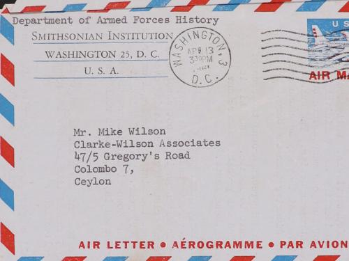 Air Letter address side: red, white and blue diagonal striped pattern around border, Smithsonian letter head in upper left-hand corner, postmark in upper middle, 10 cent stamp featuring red and white and blue airplane. Address in center of page
