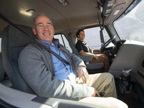 Two people in a truck smiling and posing for a picture.