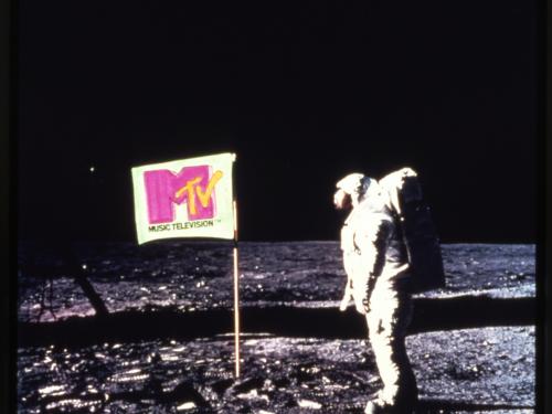 A photo of an astronaut on the Moon standing next to a flag with the MTV logo on it.