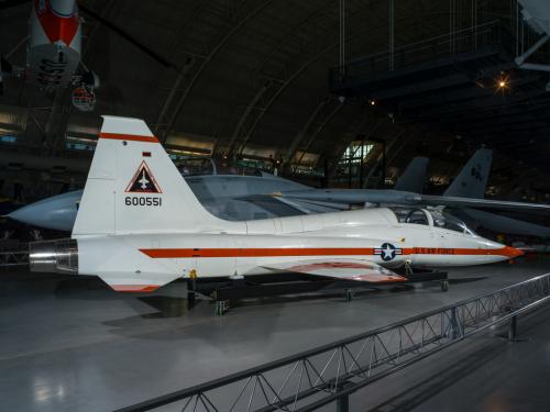 Rear view of a white and orange painted airplane in the museum hangar. 