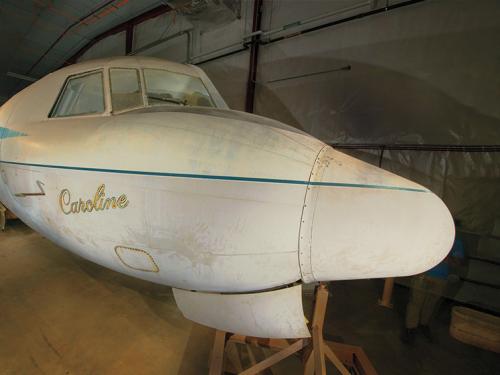 A Convair 240 airliner in a hangar with the name Caroline on the side.