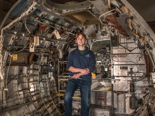 Chris Reddersen stands inside an aircraft's forward fuselage.
