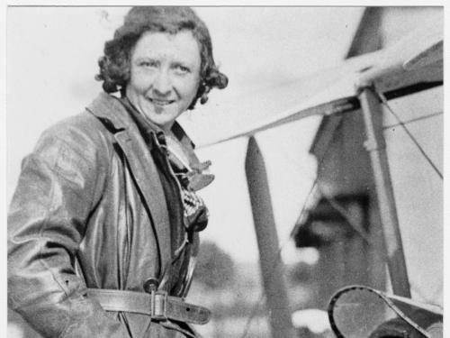 Black and white image of Maude Rose Rubens "Lores" Bonney sitting at the top of an aircraft.