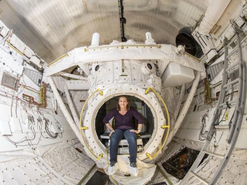 Curator sits inside an empty bay inside of Space Shuttle Discovery.