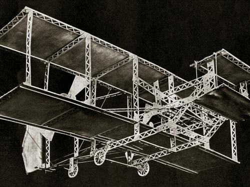 Model of a Wright-type biplane against a black background.